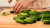 person slicing cucumbers